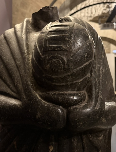 A statue of a priest holding a jar